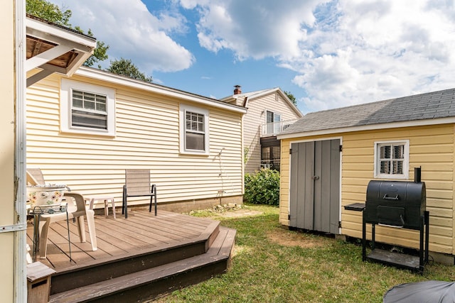 exterior space featuring an outbuilding, a wooden deck, and a storage unit