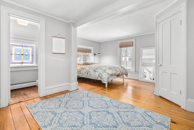 bedroom with a baseboard radiator, ornamental molding, baseboards, and hardwood / wood-style floors