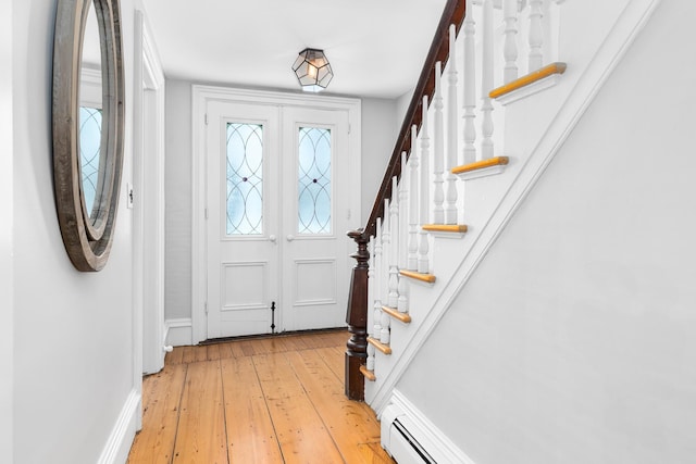 entryway with stairway, baseboards, and light wood-style floors