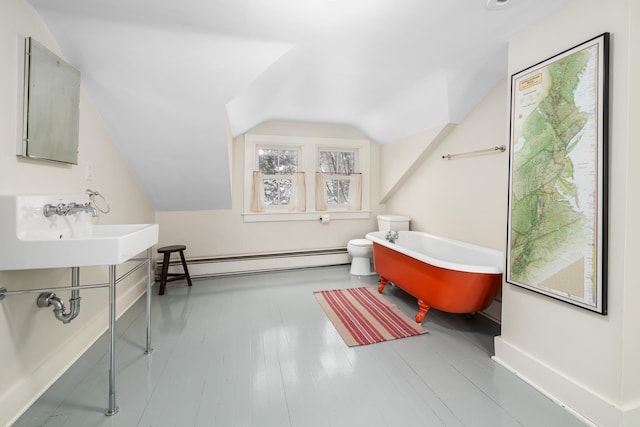 full bath featuring toilet, a sink, a freestanding bath, vaulted ceiling, and a baseboard radiator
