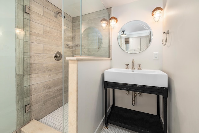 bathroom featuring a shower stall, tile patterned floors, and a sink