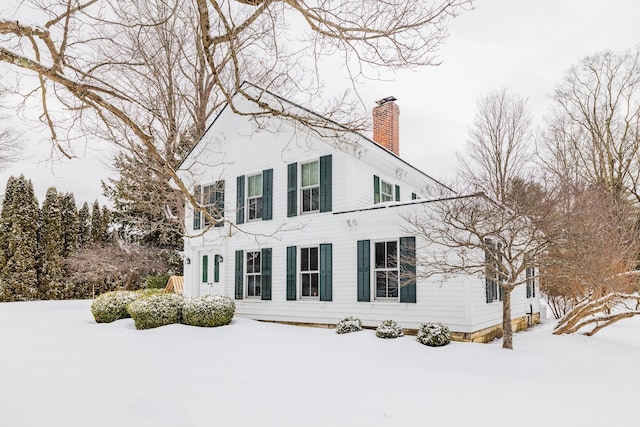 view of snow covered exterior featuring a chimney