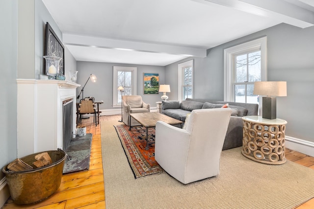 living room featuring beam ceiling, a fireplace with flush hearth, hardwood / wood-style floors, baseboards, and baseboard heating
