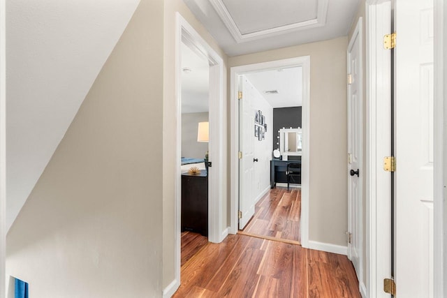 corridor with baseboards, attic access, wood finished floors, and visible vents
