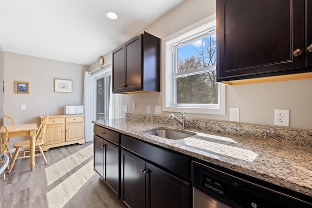 kitchen with a sink, a healthy amount of sunlight, light wood finished floors, and dishwasher