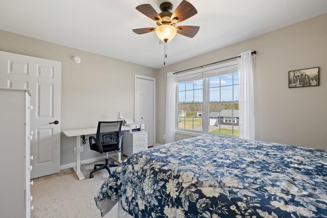 carpeted bedroom with a ceiling fan and baseboards
