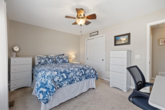 carpeted bedroom featuring a closet, ceiling fan, and visible vents
