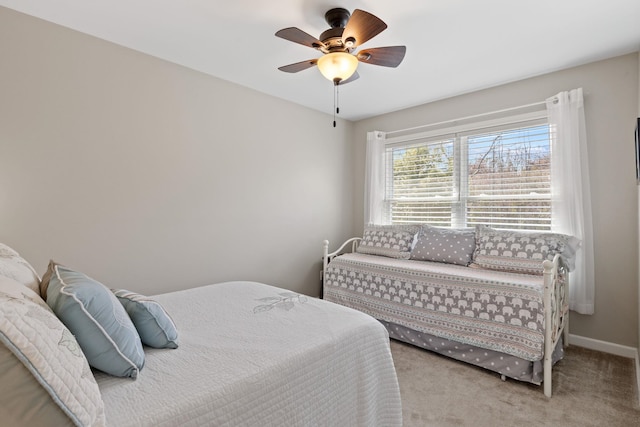 carpeted bedroom featuring baseboards and a ceiling fan