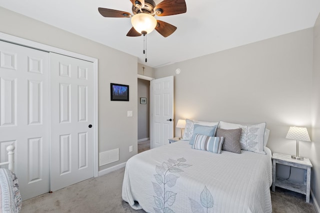 bedroom with carpet floors, visible vents, a closet, baseboards, and ceiling fan
