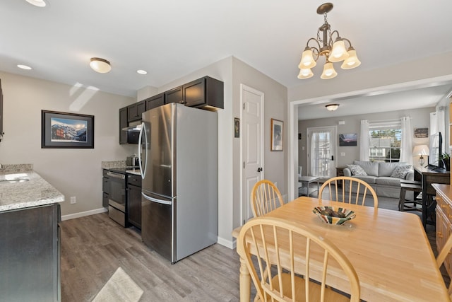 interior space with a notable chandelier, a sink, stainless steel appliances, baseboards, and light wood-type flooring