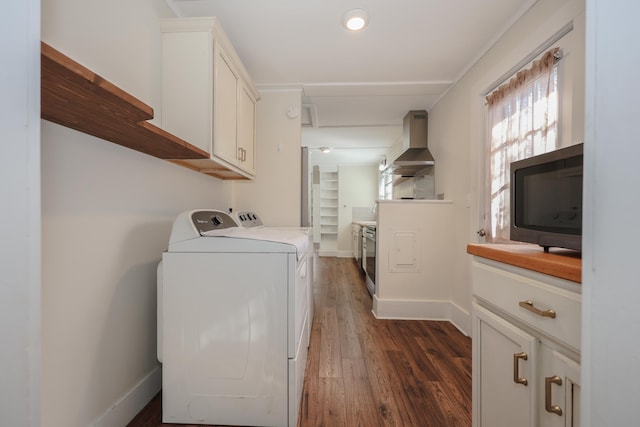 washroom with cabinet space, baseboards, dark wood finished floors, and washer and clothes dryer
