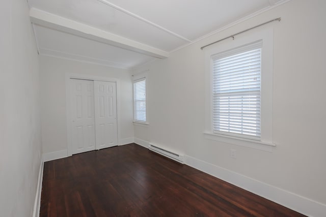 unfurnished bedroom with crown molding, baseboards, a baseboard heating unit, dark wood-style floors, and a closet