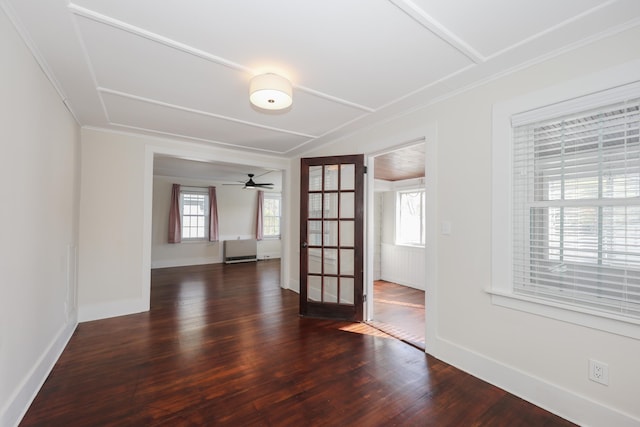 spare room with ornamental molding, dark wood finished floors, and a healthy amount of sunlight