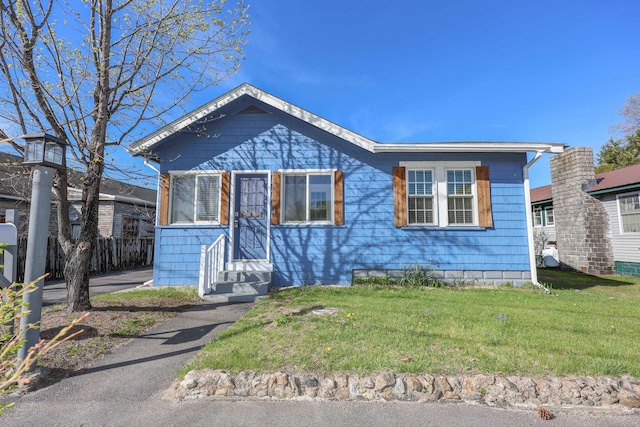 bungalow-style home featuring entry steps and a front yard