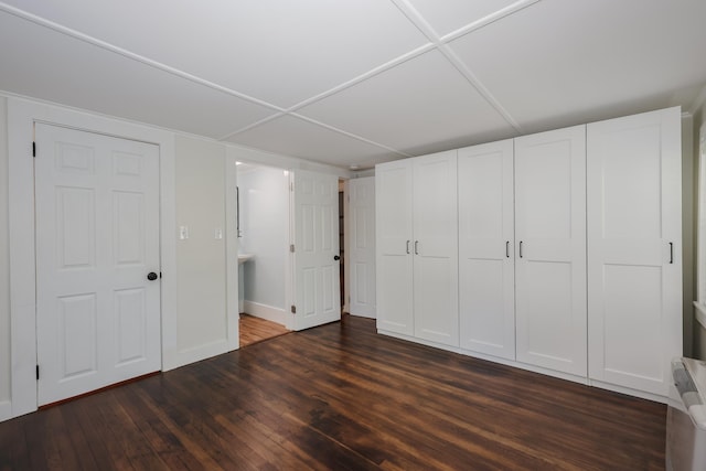 unfurnished bedroom featuring baseboards and dark wood-style flooring