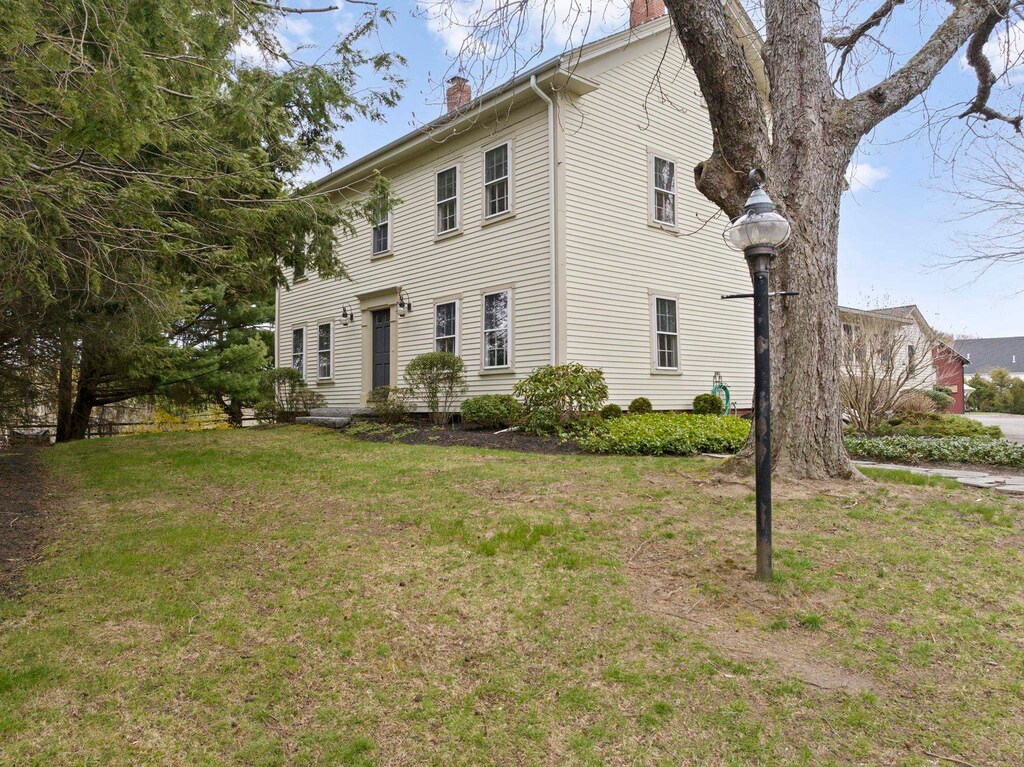 64 Kingston Rd, Exeter, NH 03833 - view of property exterior featuring a lawn and a chimney