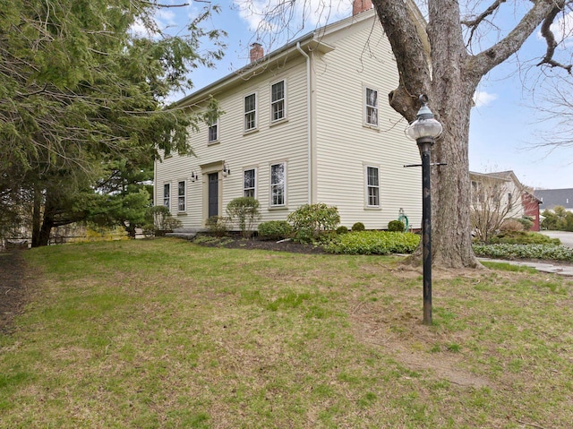 view of property exterior featuring a lawn and a chimney