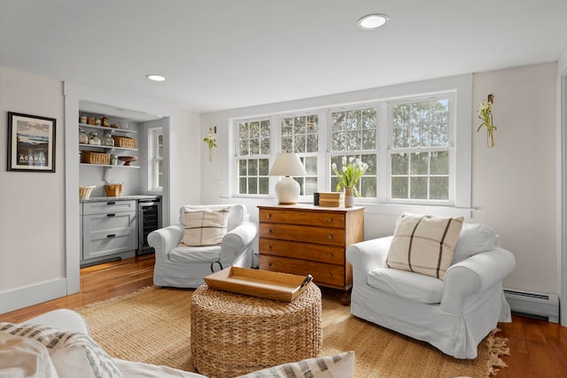 living area featuring baseboard heating, recessed lighting, wood finished floors, wine cooler, and a bar