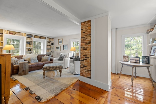 living area with baseboards, built in shelves, and hardwood / wood-style floors