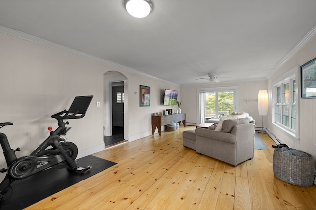 living area with ceiling fan, arched walkways, baseboards, light wood-type flooring, and ornamental molding
