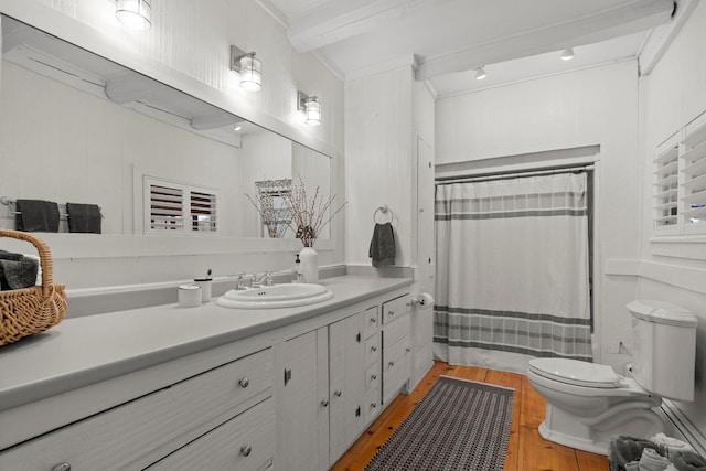 full bath with curtained shower, wood finished floors, vanity, toilet, and ornamental molding