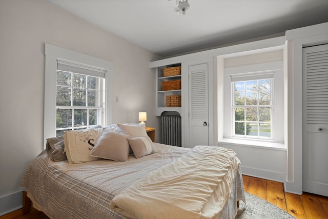 bedroom with multiple windows and light wood finished floors