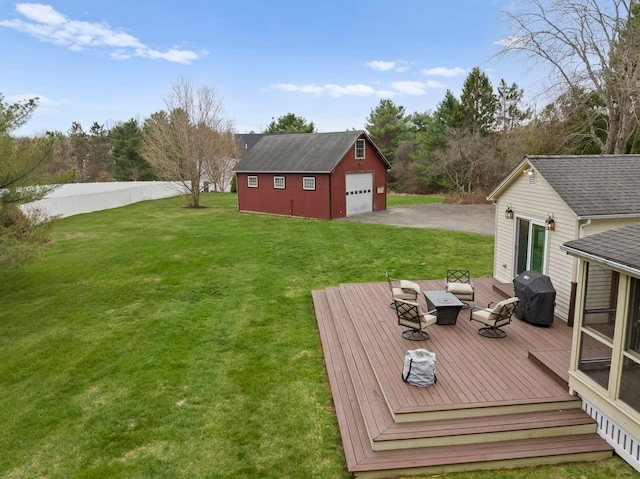 view of yard with a wooden deck, an outbuilding, driveway, and a garage