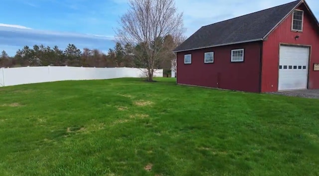 view of yard with fence, an outdoor structure, driveway, and a garage