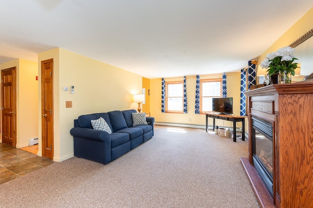 carpeted living area featuring baseboards, a baseboard radiator, and a glass covered fireplace