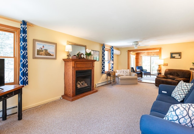carpeted living area with a glass covered fireplace, baseboards, a wall mounted air conditioner, a baseboard radiator, and a ceiling fan