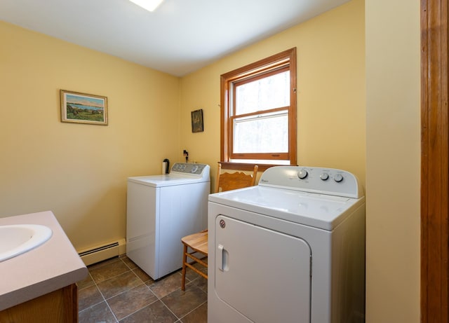 clothes washing area with washer and dryer, laundry area, a sink, and a baseboard radiator