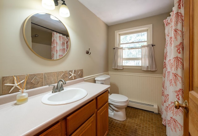 bathroom featuring vanity, a wainscoted wall, baseboard heating, and toilet