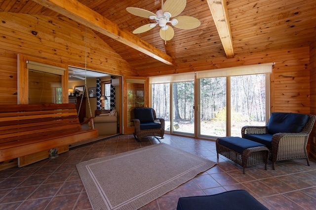 living room with a ceiling fan, wood walls, tile patterned floors, wooden ceiling, and lofted ceiling with beams