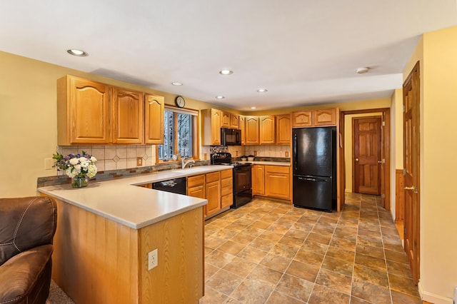 kitchen with tasteful backsplash, a sink, black appliances, a peninsula, and recessed lighting