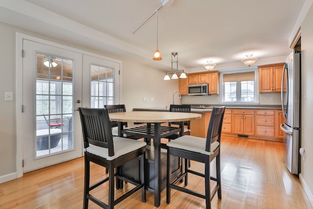 dining room featuring baseboards and light wood-type flooring
