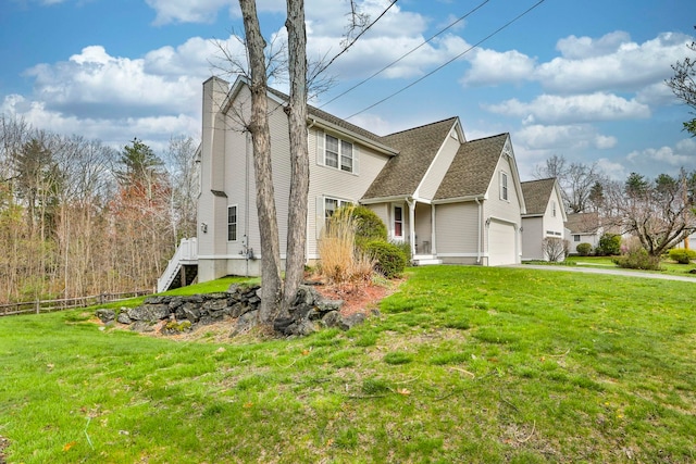 view of home's exterior featuring a lawn, an attached garage, and fence