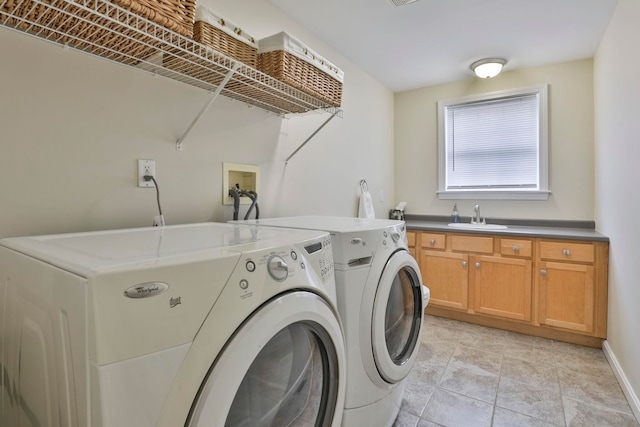 clothes washing area with a sink, separate washer and dryer, baseboards, and cabinet space