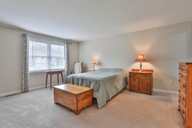 bedroom featuring baseboards, light colored carpet, and visible vents