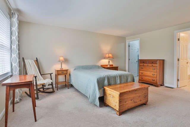 bedroom with baseboards and light carpet