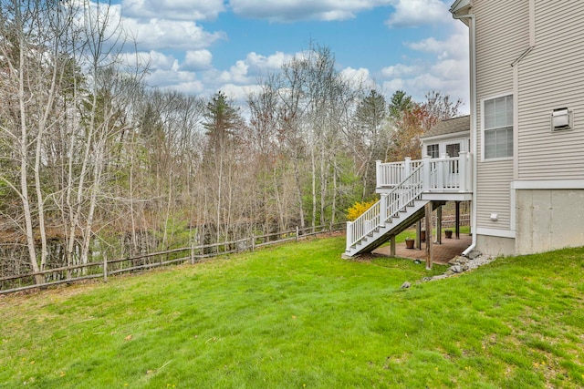 view of yard featuring a fenced backyard, a wooden deck, and stairway