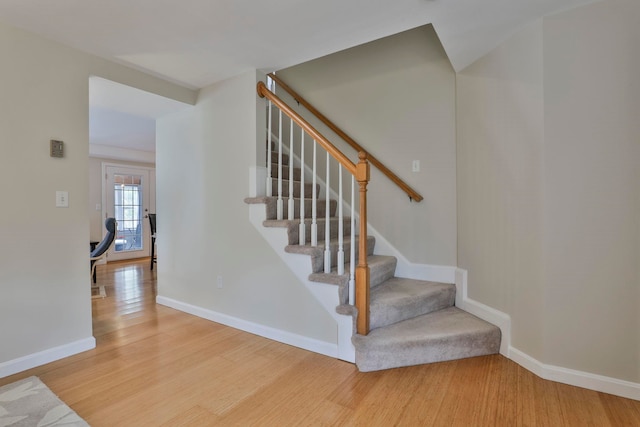 stairs with baseboards and wood finished floors