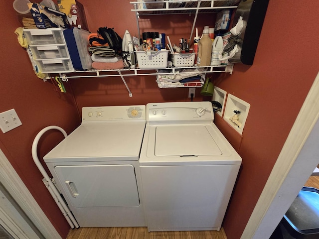 laundry area featuring washer and dryer, laundry area, and wood finished floors