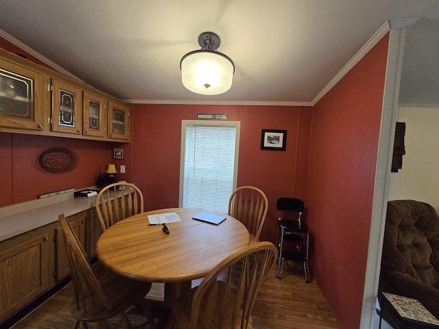 dining space with ornamental molding and dark wood-type flooring