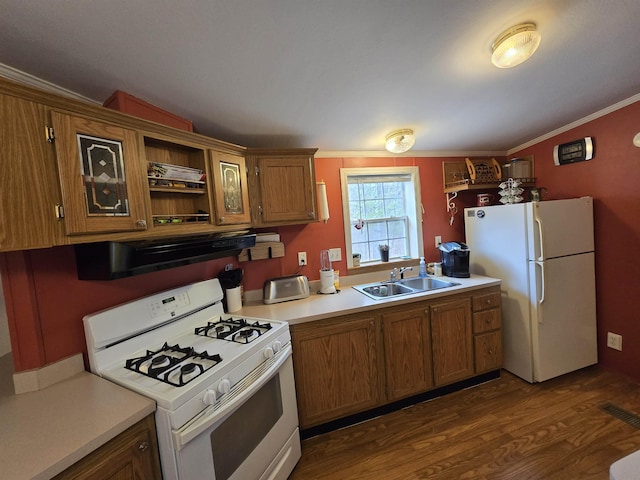 kitchen with white appliances, light countertops, brown cabinets, a sink, and dark wood finished floors