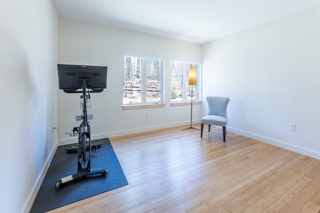 exercise area with baseboards and wood finished floors