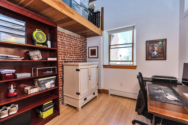 office space with baseboards, light wood-style flooring, and baseboard heating