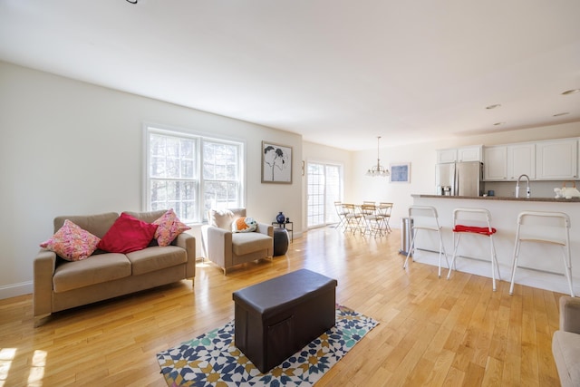 living room featuring light wood-style floors and a chandelier