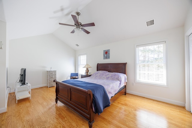 bedroom featuring a ceiling fan, visible vents, light wood-type flooring, baseboards, and lofted ceiling