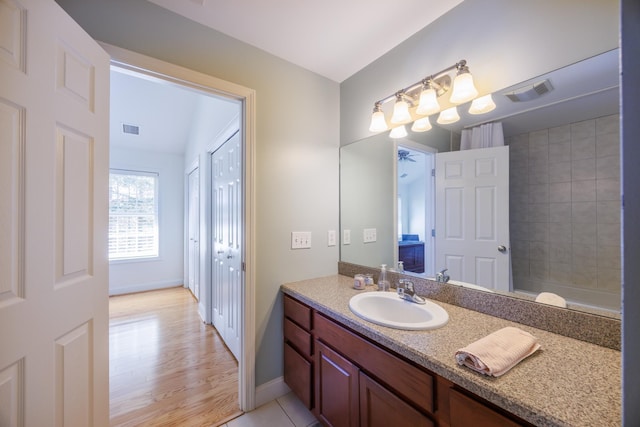 full bath featuring vanity, baseboards, wood finished floors, and visible vents