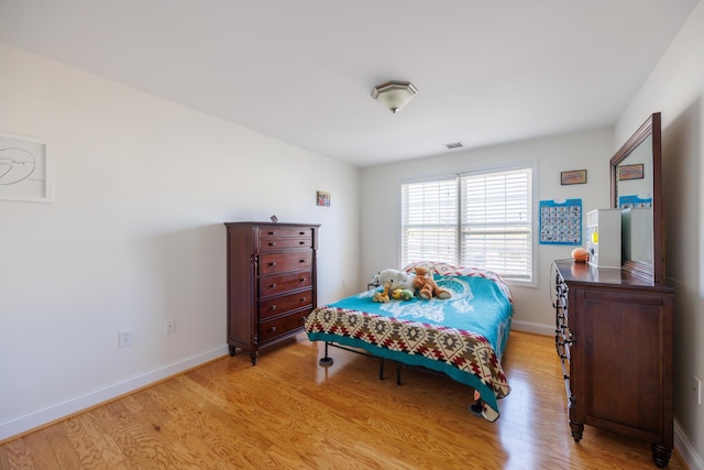 bedroom featuring baseboards, visible vents, and light wood-type flooring